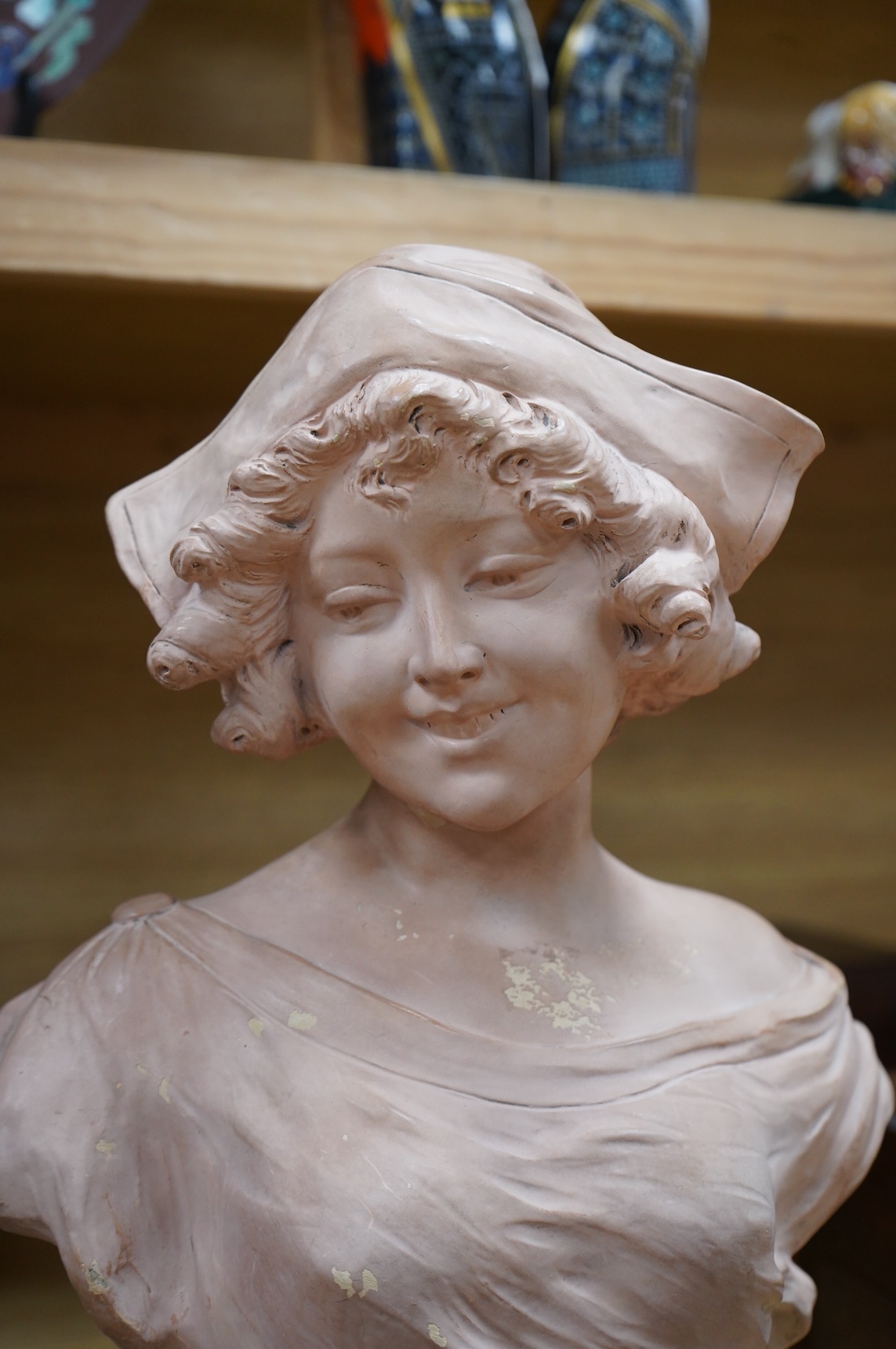 A painted terracotta bust of a maiden, indistinctly signed and numbered 1320, 41cm high
